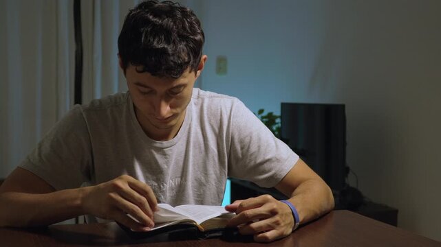Hombre joven leyendo la Biblia en mesa