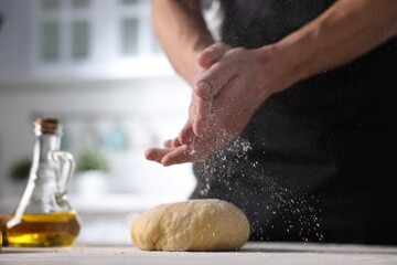 Fototapeta premium Man with dough at table indoors, closeup