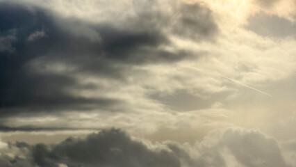 Obraz premium Warsaw, Poland, March 15, 2026. Dramatic grey storm clouds filling the sky with hints of golden sunlight breaking through the haze. High quality photograph.