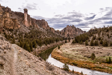 Fototapeta premium River winds through rugged canyon, flanked by tall rock spires