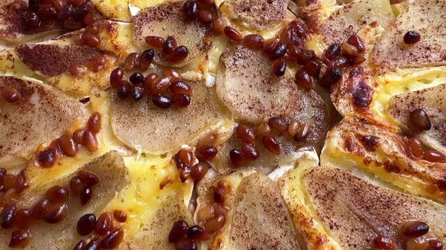 Homemade pear and camembert cheese pie baked on parchment paper. Gourmet sweet and savory pastry with melted cheese and pear slices, perfect for food blogs, recipes, and culinary publications.