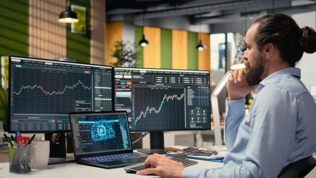 Portfolio manager in office using AI software on laptop to evaluate capital allocation based on economic graphs. Day trader using deep learning on notebook to do research driving growth