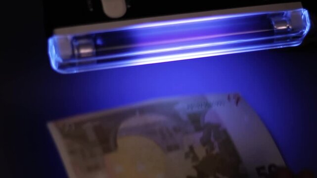 Authentication of a fifty-euro banknote under ultraviolet light. Video