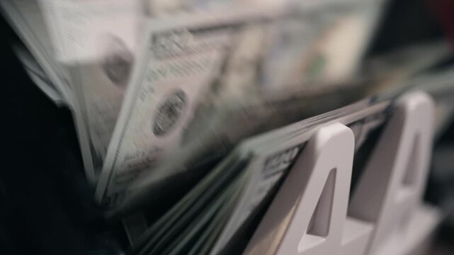 Modern money counter processing one hundred dollar bills. Finance concept.
