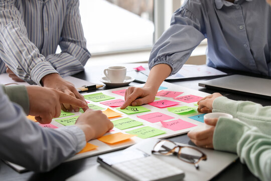 Group of people with sticky notes working on business plan in office