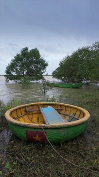 A traditional Vietnamese coracle rests on the shore in Vietnam. These boats are used by local fisherman to navigate the waterways in Vietnam, Hoi An.