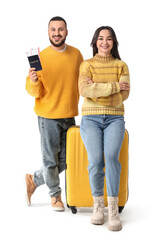 Young couple with passport and suitcase on white background. Travel concept
