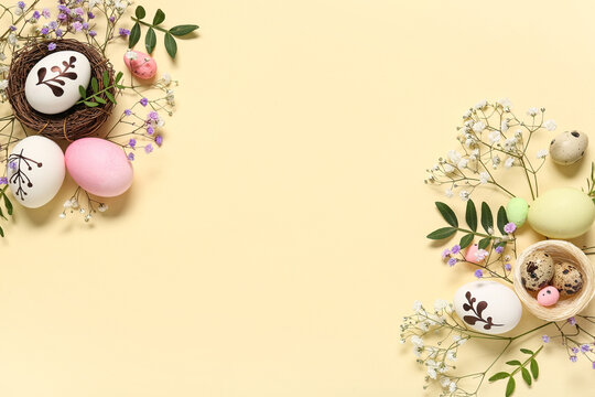 Easter eggs with beautiful gypsophila flowers and leaves on beige background
