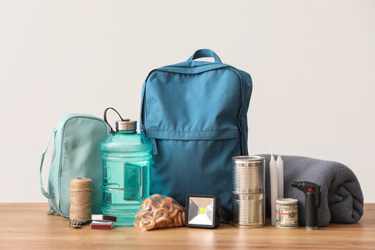 Emergency backpack with necessities on table near light wall