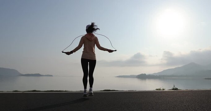 Fitness woman rope skipping  at seaside