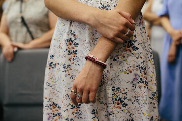 Woman's hands praying white floral dress