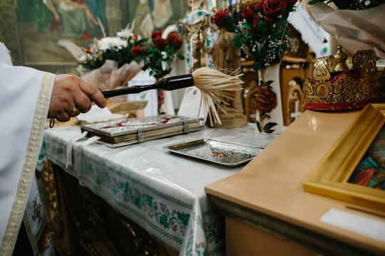 Priest performing christian ritual with holy water aspergillum