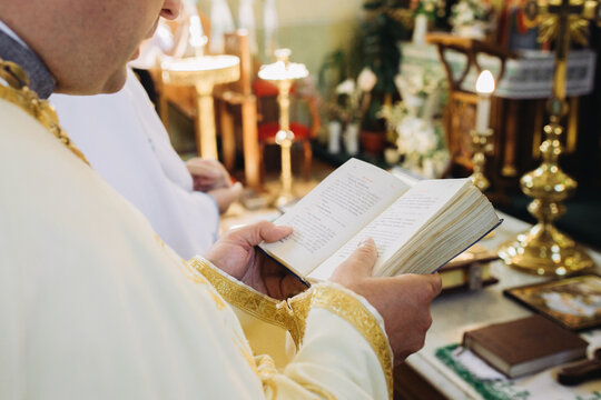 Priest reading from prayer book during christian wedding ceremony