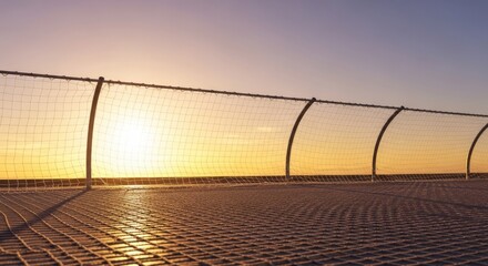 Fototapeta premium Intricate safety netting at the edge of a platform, illuminated by the warm, golden hues of a beautiful sunset, offering secure protection, safety, intricate, security