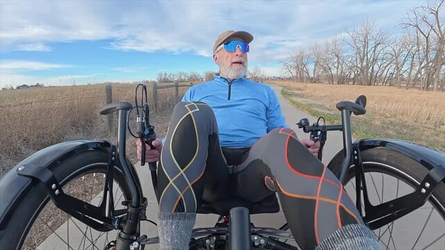 Senior cyclist is riding a recumbent trike on bike trails in Boyd Lake State Park, Colorado