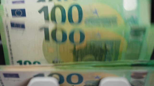 Counting one hundred euro banknotes in modern electronic money counter. Accounting concept.
