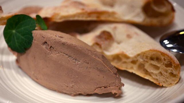 Close up of a pate served with toasted bread on a white plate