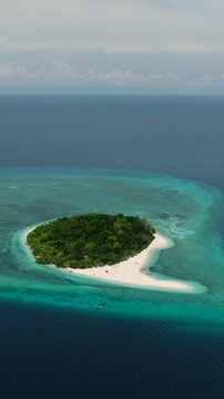 Small island surrounded by white beach. Mantigue Island. Camiguin, Philippines. Vertical video.