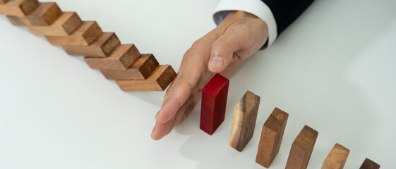 insurance with hands protect domino. Businessman hands stop dominoes falling in business crisis....