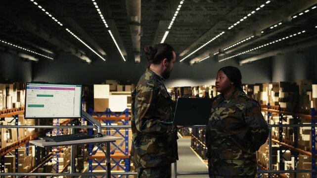 Black military personnel working on laptop in armed forces facility with defense cargo, inspection and inventory control to ensure supply chain shipment. Officer ensuring command and control.