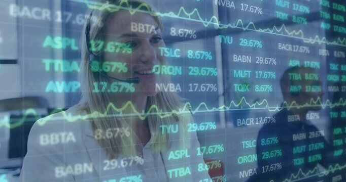 Responding to live market data overlay, headset-clad woman speaking and noting with pen at desk