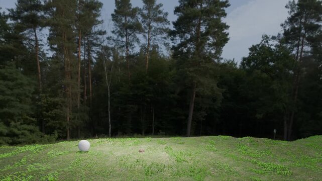 Realistic 3D animation of a soccer ball going back and forth on an uneven, grassy field.