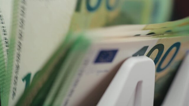 Professional money counter processing &euro;100 bills for accurate cash counting. Accounting concept.
