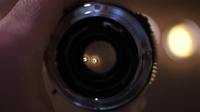 Close up of professional camera lens with aperture and focus rings being adjusted by hand