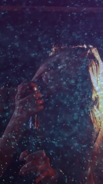 Singer gripping mic, hearing drum cue, flipping hair, singing during live music set amid particles