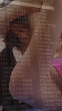 Vertical video: Woman ending reps on fitness mat tying hair for class while code overlay showing