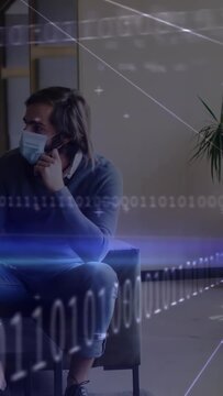 Vertical video: Office man adjusting mask, gesturing to offframe cue, data overlay obscuring scene