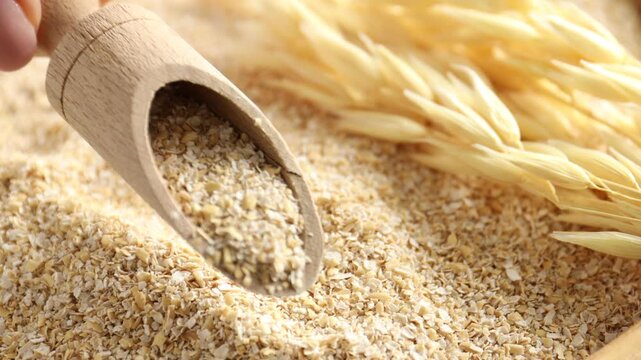 Woman taking scoop with oat bran, closeup