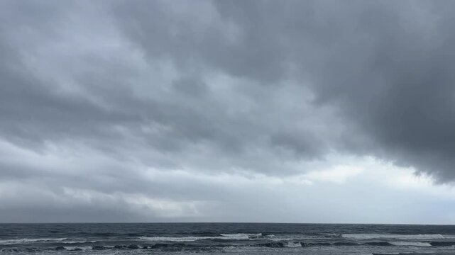 曇り空の下に広がる荒れた海と水平線