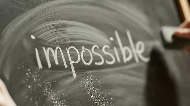 Hand erases 'im' from 'impossible' to 'possible' on chalkboard, symbolizing resilience, International Youth Day, and youth mental health.