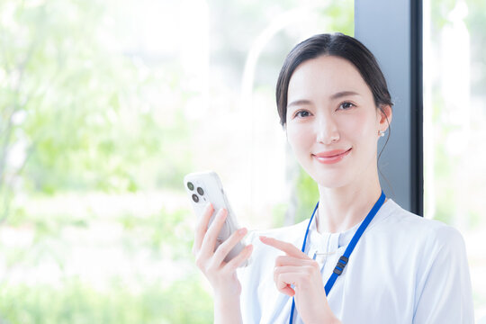 ビジネス女性がスマホを指差しCTA(cta) タップして行動喚起で登録や申し込みやお問合せを促す広告イメージ　カメラ目線
