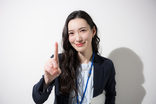 ビジネス女性が指差しでCTA 行動喚起を促す信頼と選択のビジネスイメージ白背景カメラ目線でマーケティングイメージ