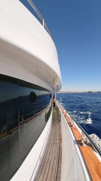 Vertical view of yacht side deck with tinted window floating in the sea