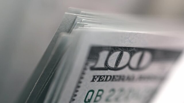 Close-up of one hundred dollar bills running through electronic money counter. Finance concept.
