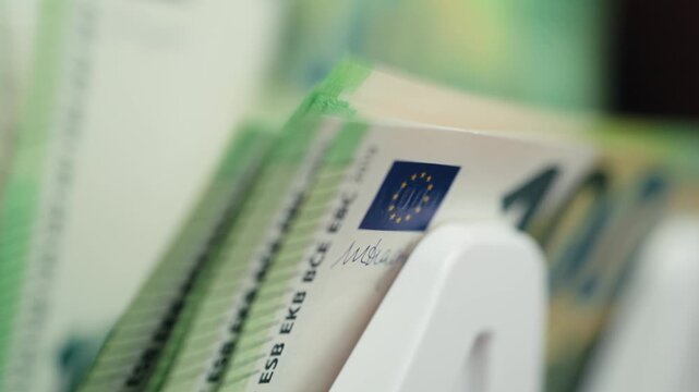 Counting one hundred euro banknotes in high-speed money counter with display. Accounting concept.

