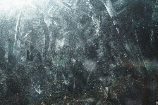 The glass surface texture is dirty with fingerprints and dust spots under bright light.