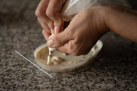 Relleno de molde con chocolate blanco usando manga pastelera, inicio del proceso de reposter&iacute;a artesanal