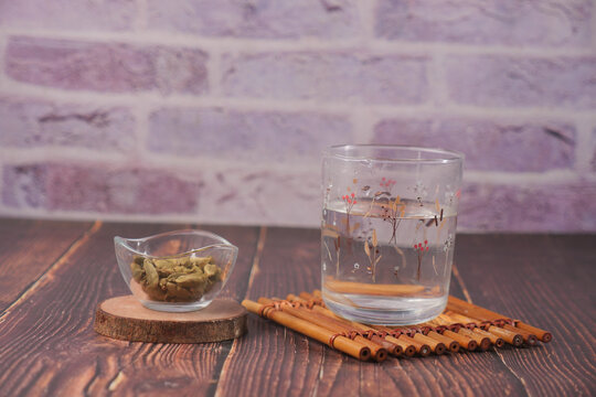 Hot water with cardamon sits on a wooden table