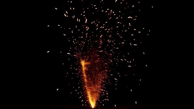 Bright orange sparks and fire fountain erupting upwards against a solid black background, perfect for celebration effects.
