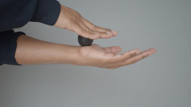 Close up video of person massaging forearm with therapy ball for relaxation and pain relief