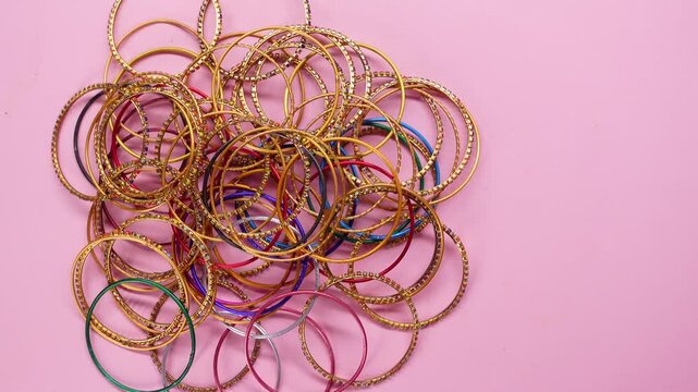 Different types of bangles on a pink background