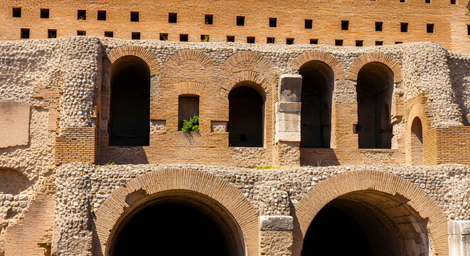 Ancient brick wall with arched windows and square holes under sunlight