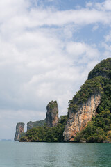 Naklejka premium Towering limestone cliffs and karst formations overlooking the tropical coastline of Ao Nang Krabi Thailand