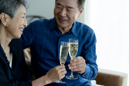 シャンパンで乾杯する日本人シニア夫婦