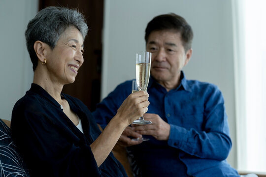 シャンパンで乾杯する日本人シニア夫婦