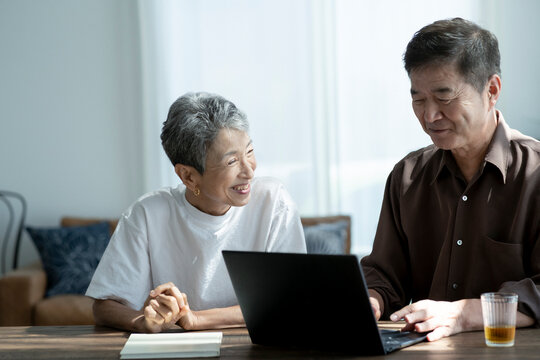 ノートパソコンを見る日本人シニア夫婦